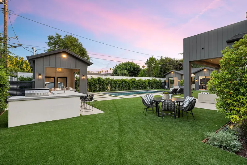 Modern concrete pool patio deck with outdoor kitchen island