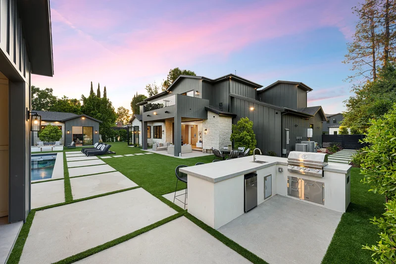 Modern outdoor kitchen with concrete countertop and turf-joint pavers.